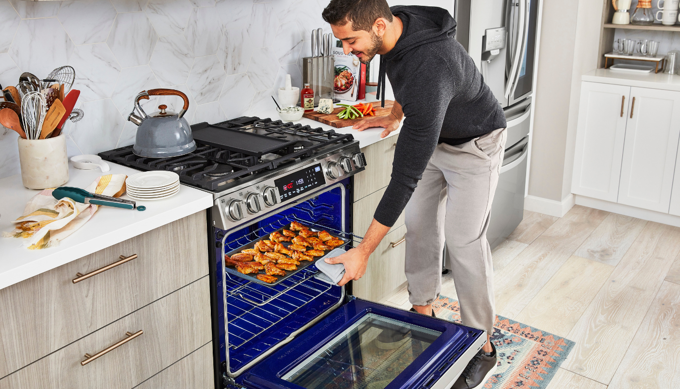 LG InstaView Slide In Range being used by a man putting food into the oven.